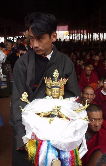 Tibetan man waiting in line with an idol at the 2003 Kalachakra Initiation, Bodhgaya.