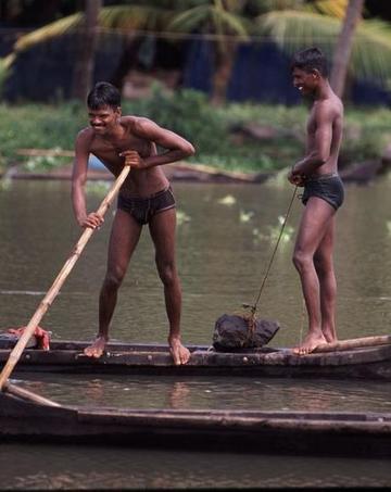 Men poling their boats in the backwaters near Fort Cochin, Kerala state.