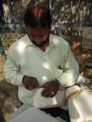 Man sewing up a package, Hyderabad post office.