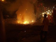 A boy looks at the smouldering ruins of crackers that he lit.